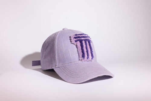 A light lavender baseball cap with a textured, embroidered purple TUFTED logo on the front, photographed on a clean white studio background.