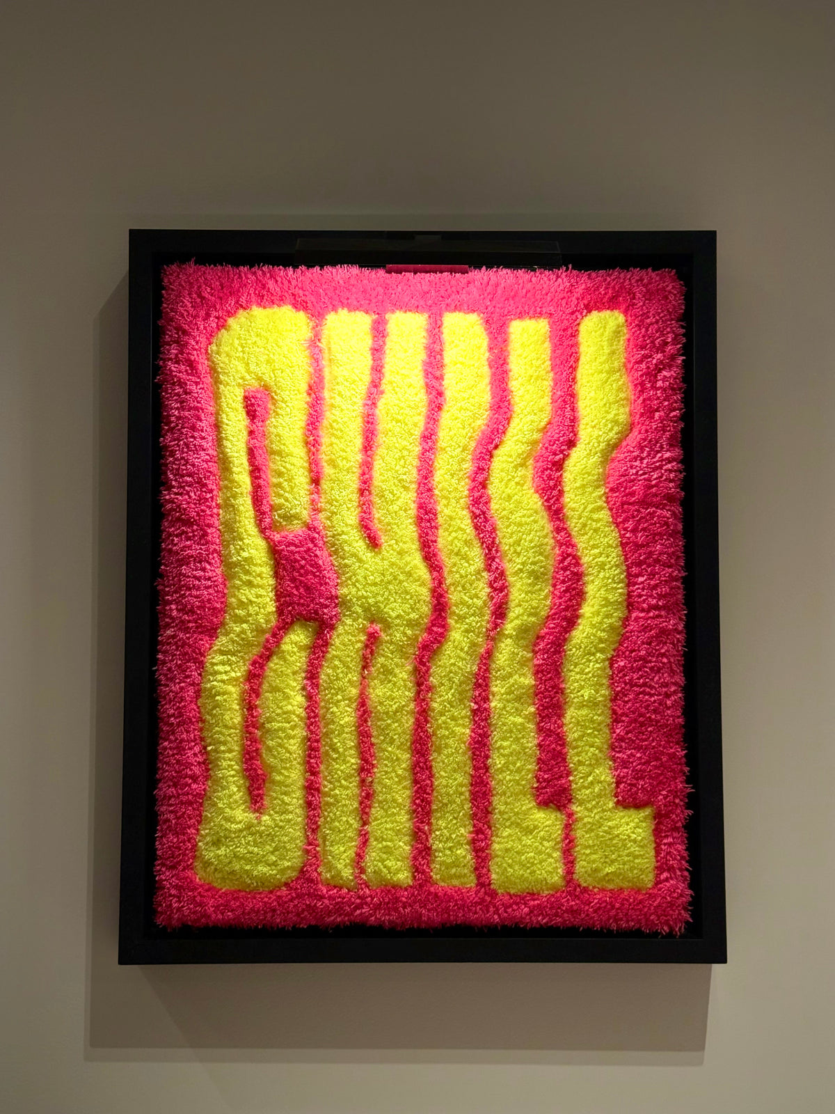 CHILL, œuvre tuftée contemporaine rose et jaune de Ninon Dechavanne, encadrée dans une caisse américaine noire.