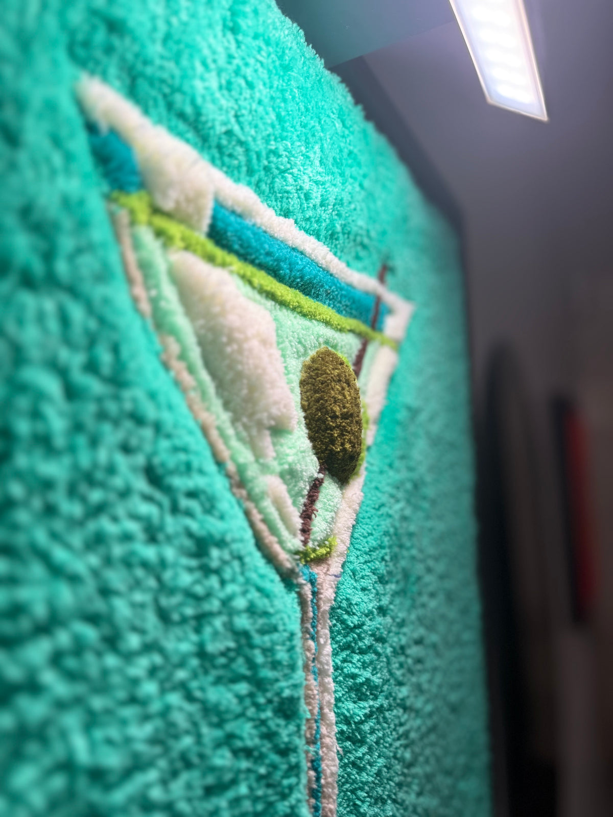 Détail en relief de VESPER, œuvre tuftée contemporaine de Ninon Dechavanne représentant un verre à cocktail et son olive.