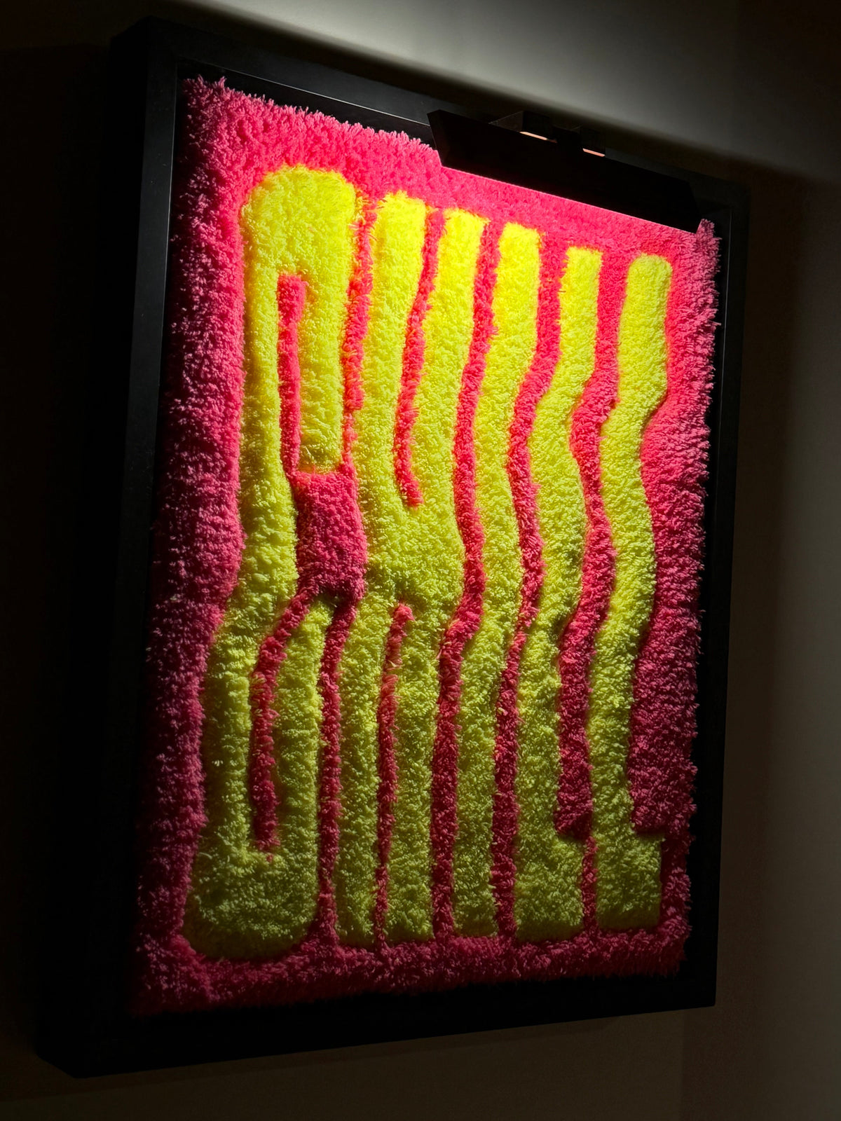CHILL, œuvre tuftée rose et jaune de Ninon Dechavanne, photographiée éclairée pour révéler le relief et la texture du tufting.